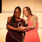 Dr. Natasha Johnson receives a 2023 Women of Distinction Award from Award Sponsor, Hamilton Tiger Cats